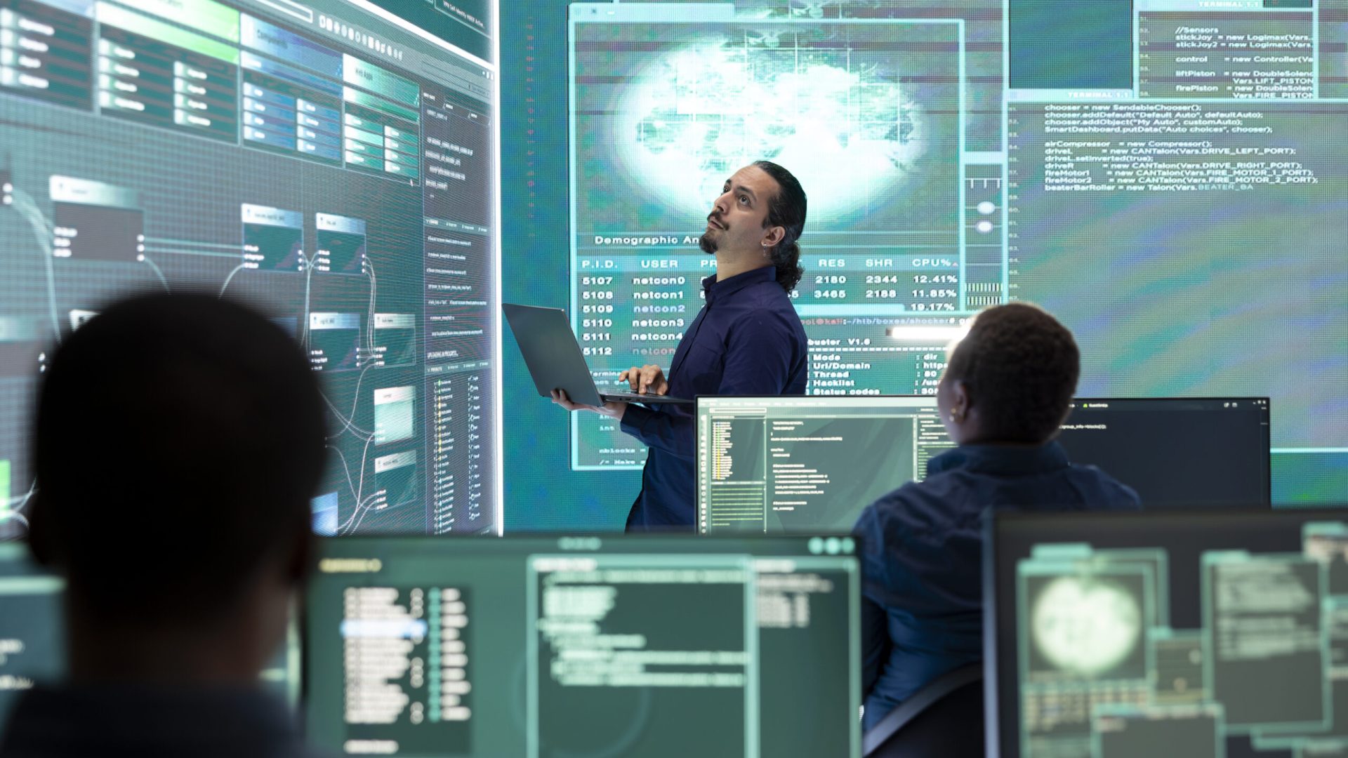 Professional hacker using ransomware and phishing tactics to compromise networks and gather intelligence for national security during cyberwarfare. Governmental spyware on big screen.